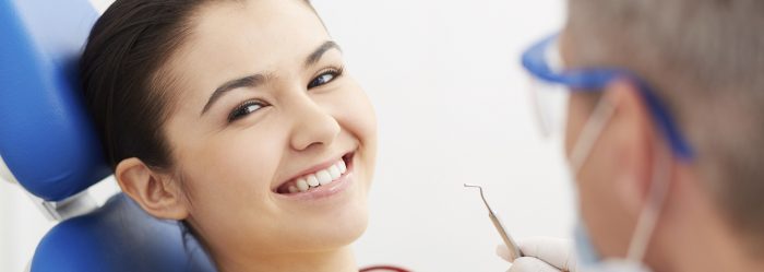 Image of smiling patient looking at camera at the dentists