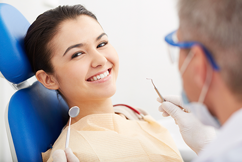 a smiling school-age child in the dentist's chair