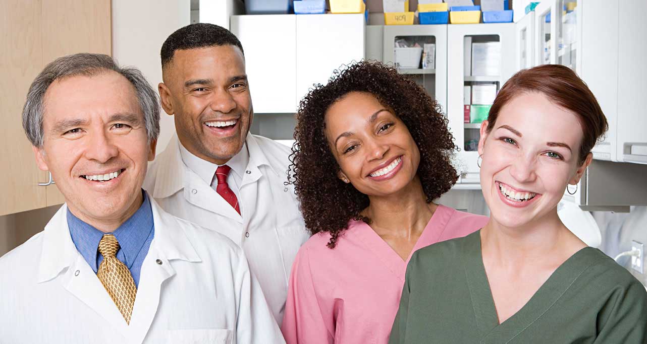 Doctor, pharmacist, and medical team smiling.